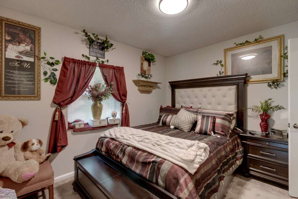 Cozy bedroom with plush bedding, decorative pillows, and teddy bear on the side at 123 Club in Beaufort, South Carolina