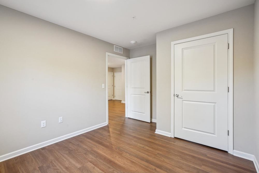 Spacious bedroom with wood-style flooring at Alley Landing in Des Moines, Iowa