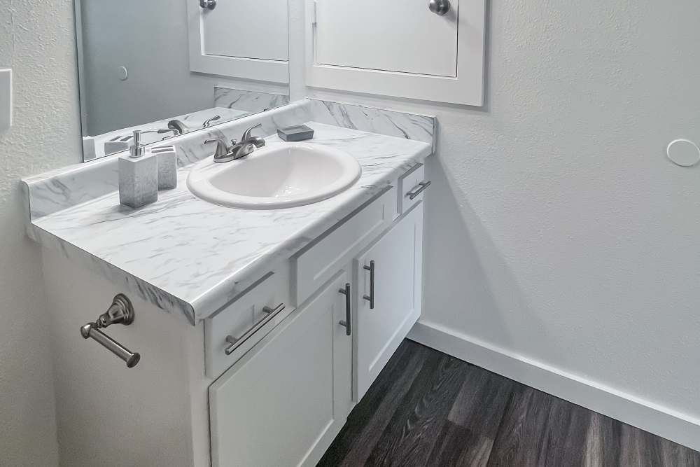 Sink in the bathroom with wooden flooring at Savannah Square & Savannah Harbor in Norman, Oklahoma