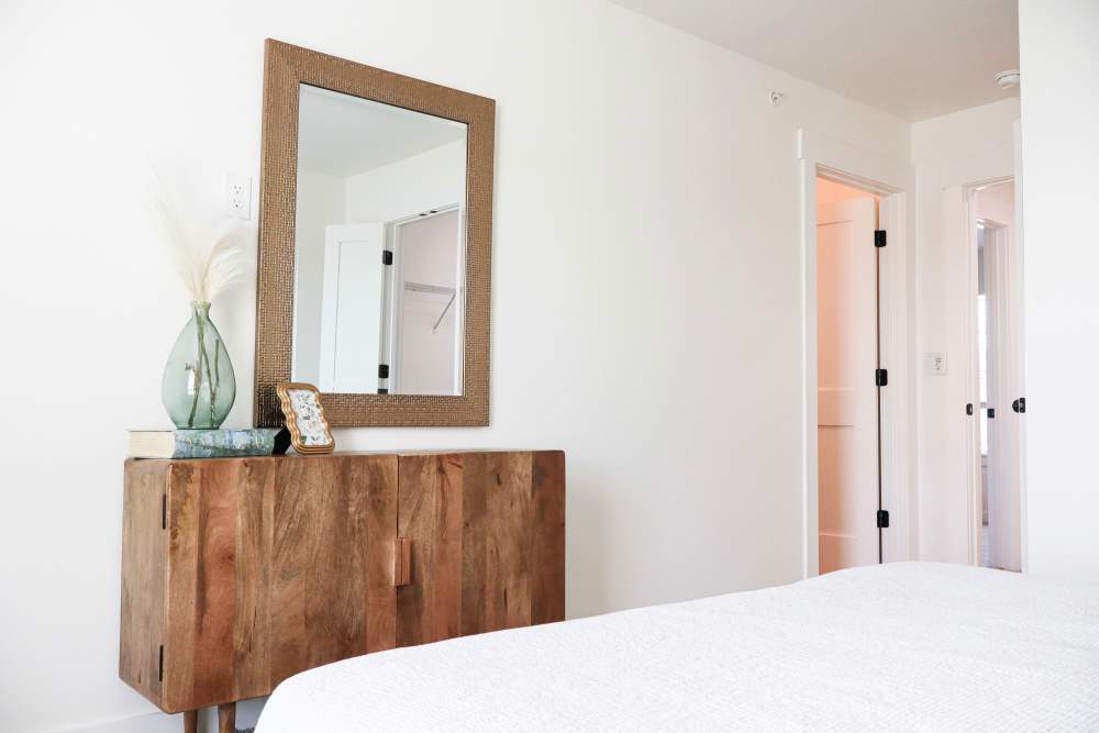 Bright bedroom with modern wooden furniture at Copper Trail Townhomes in Owasso, Oklahoma