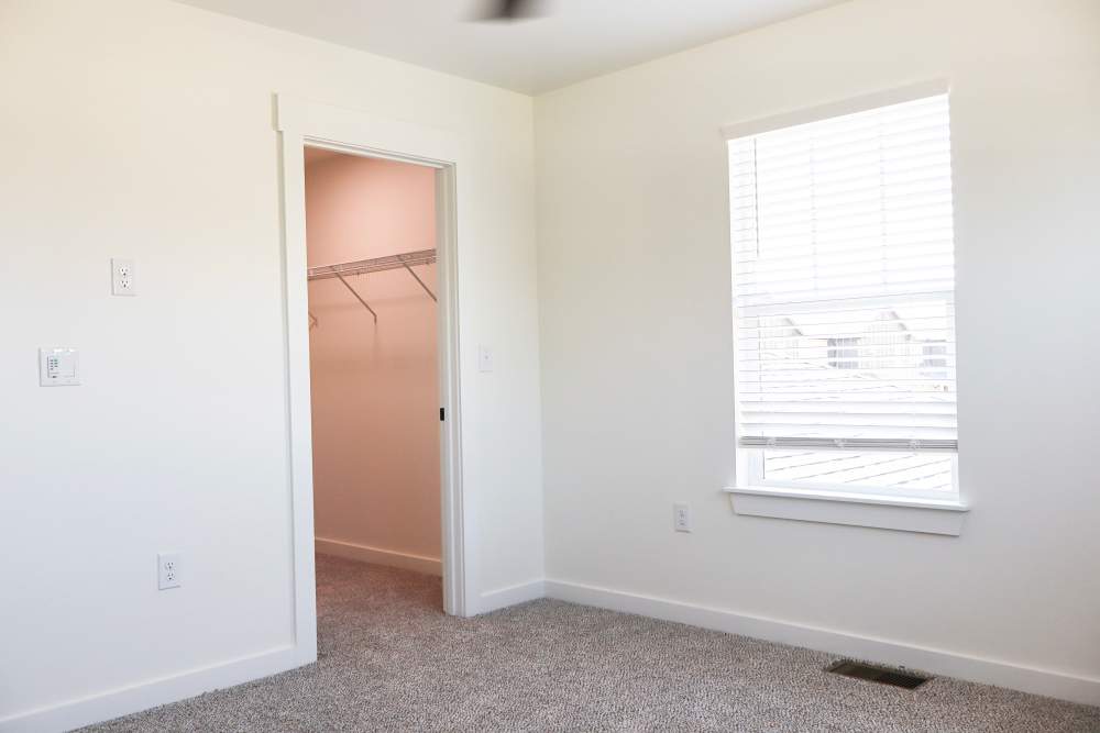 Bright bedroom with spacious closet and window at Copper Trail Townhomes in Owasso, Oklahoma