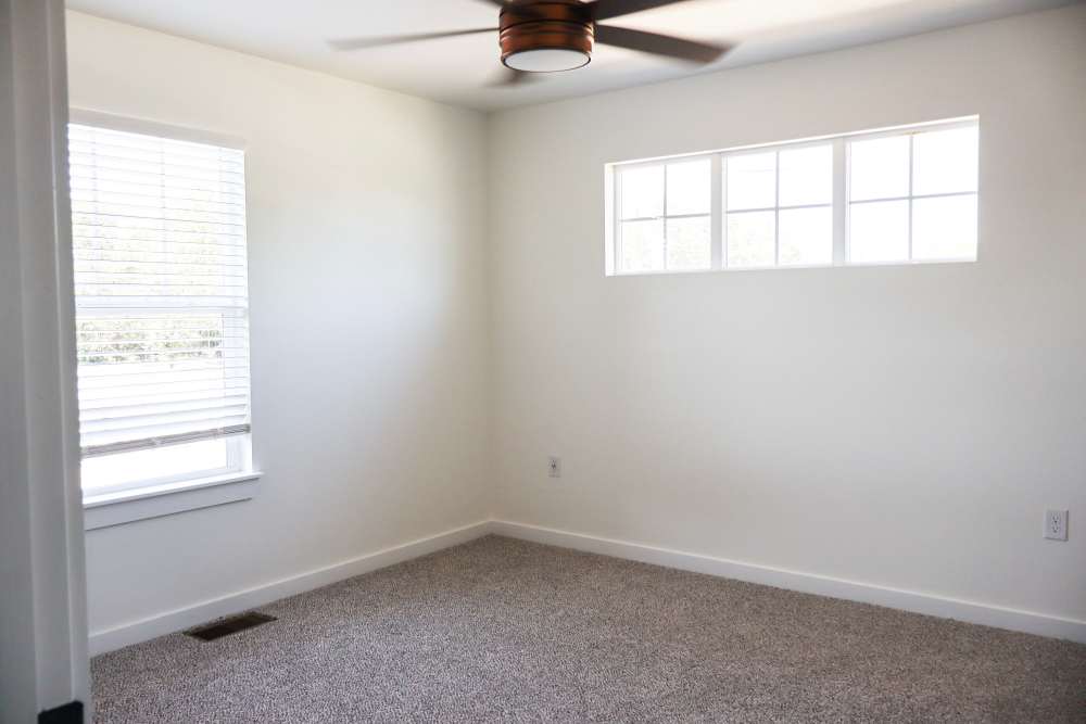 Bright room with carpeted flooring and windows at Copper Trail Townhomes in Owasso, Oklahoma