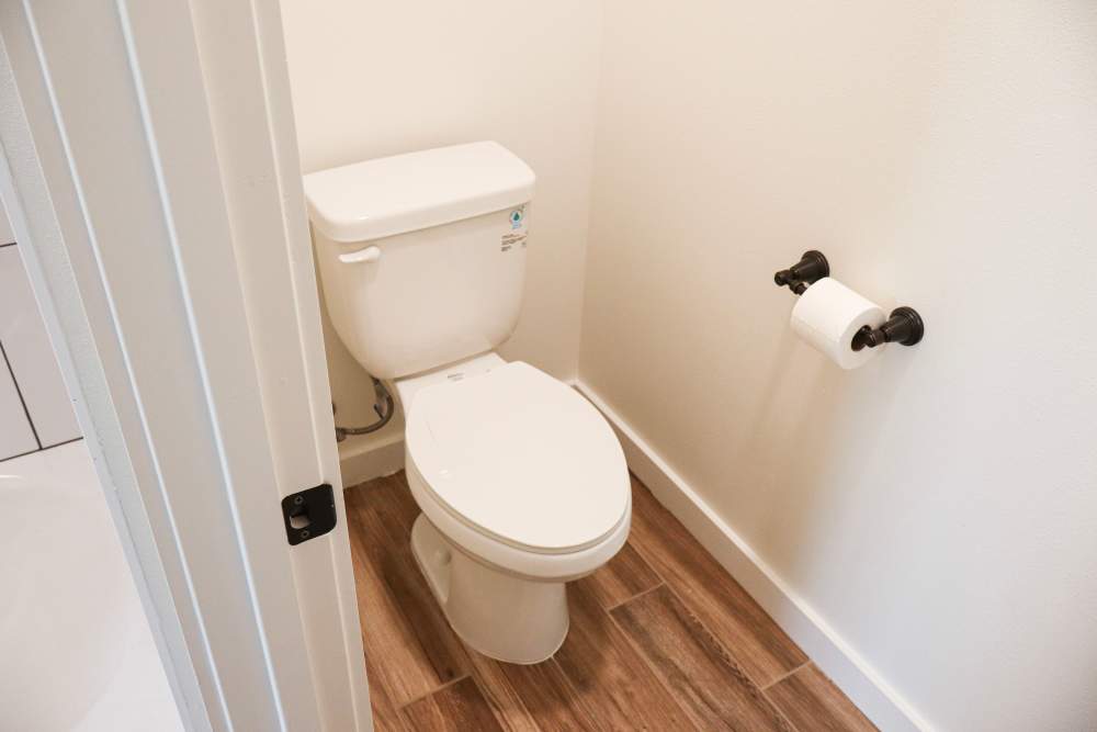 Modern bathroom with wood-style flooring at Copper Trail Townhomes in Owasso, Oklahoma
