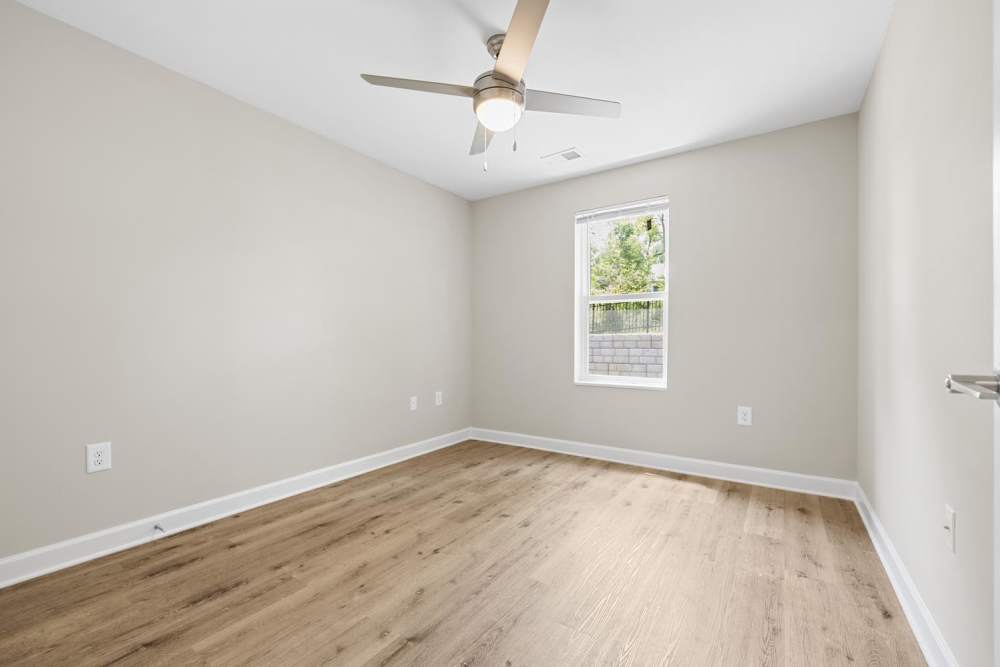 Bedroom with wood-style flooring at Bluebird Commons in Statesville, North Carolina