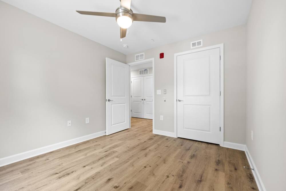 Apartment bedroom with wood-style flooring at Bluebird Commons in Statesville, North Carolina