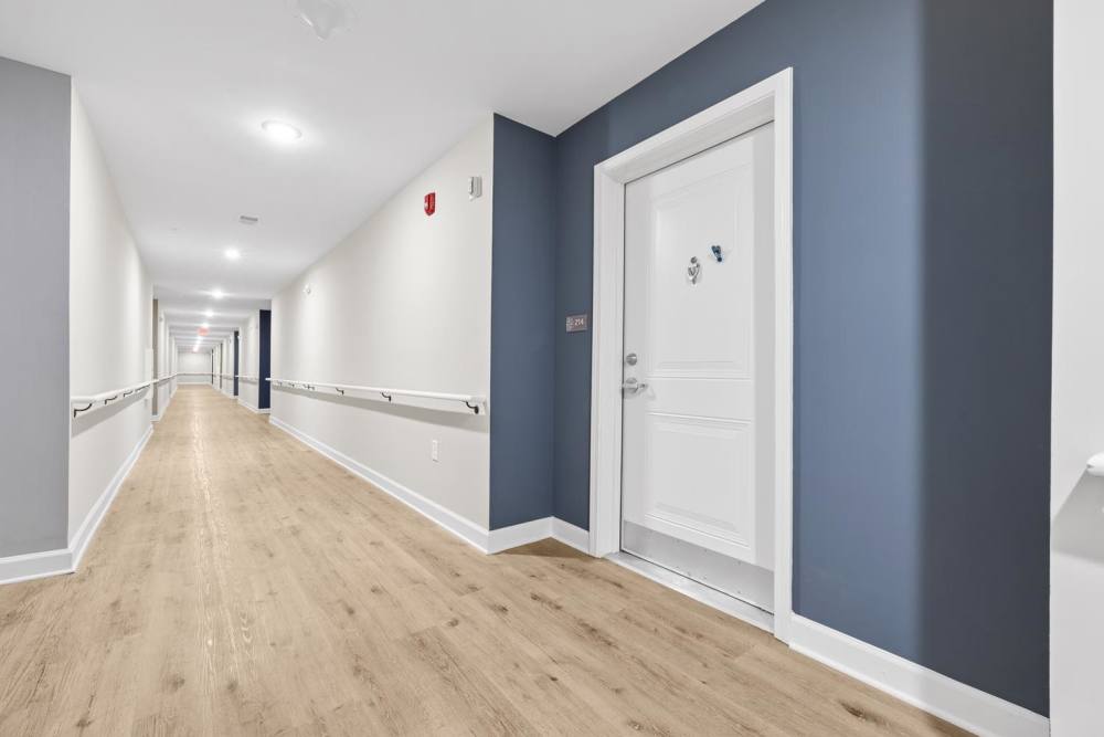 Hallway with wood-style flooring at Bluebird Commons in Statesville, North Carolina
