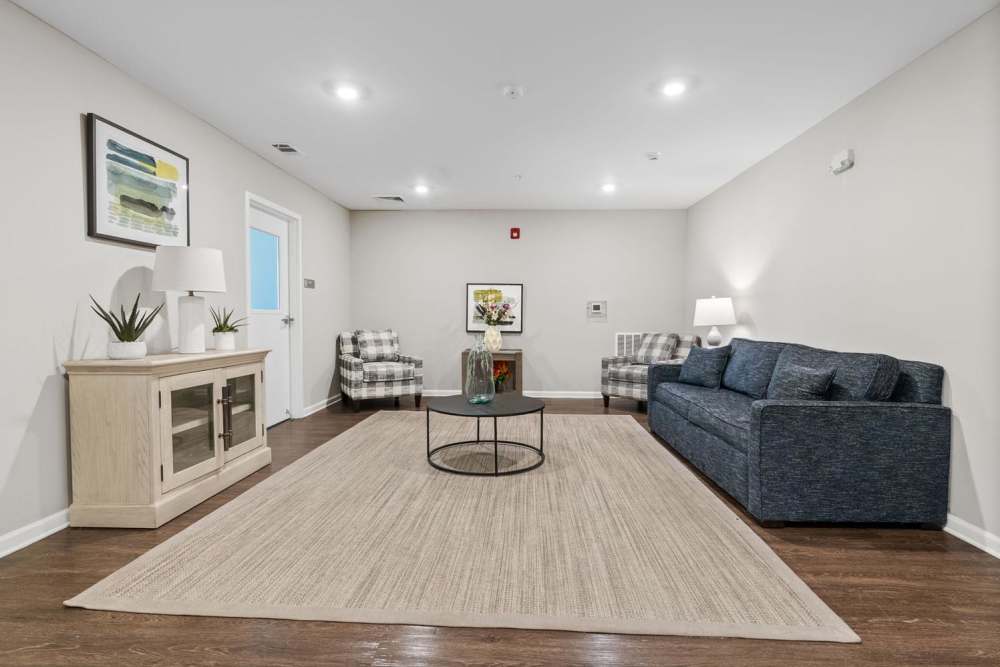 Cozy living room with wood-style flooring, modern furniture, and decorative plants on a side table at Rooney Ridge in Roanoke Rapids, North Carolina