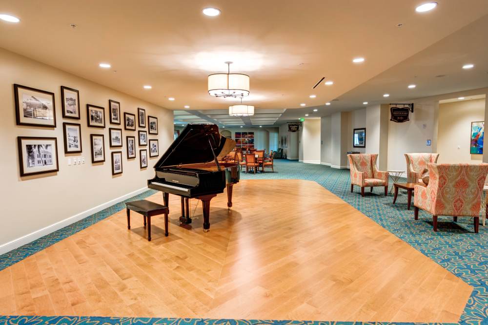Lounge with grand piano and wood-style flooring at Barclay House of Stuart in Stuart, Florida