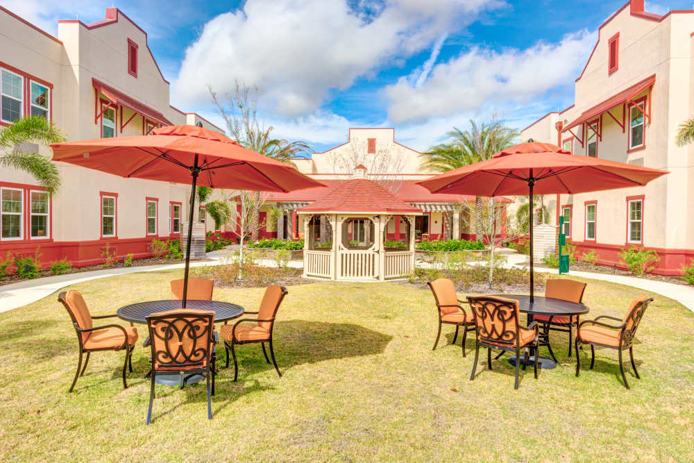 Outdoor seating area with umbrellas and gazebo at Barclay House of Stuart in Stuart, Florida