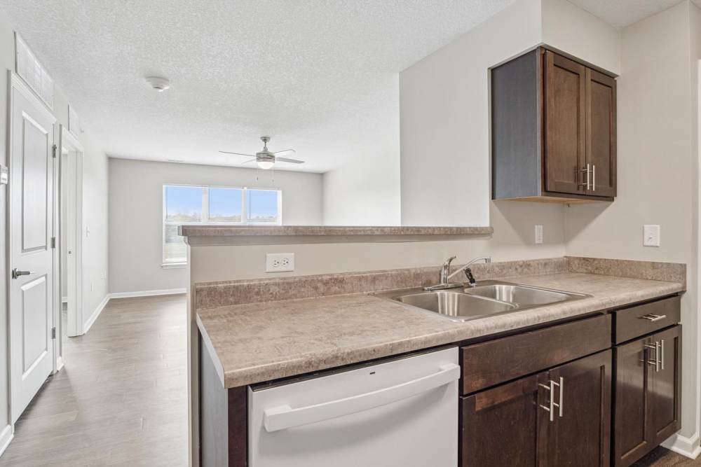 Modern kitchen with granite countertops, stainless steel appliances with a sink at Johnston Crossing I in Johnston, Iowa