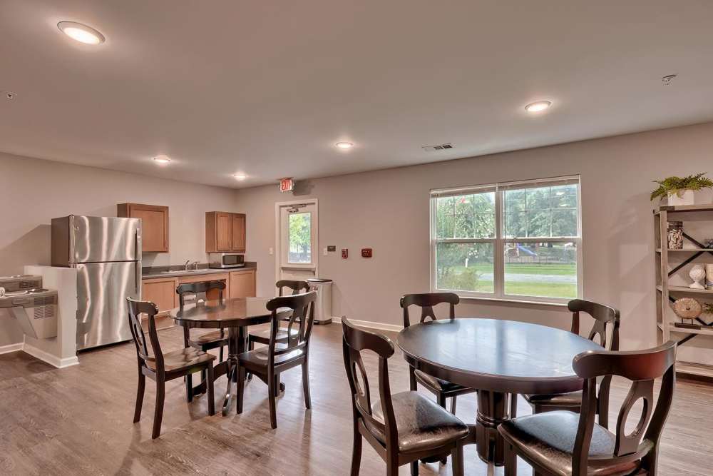 Community lounge with dining tables and kitchen at Lowcountry Crossing in Denmark, South Carolina