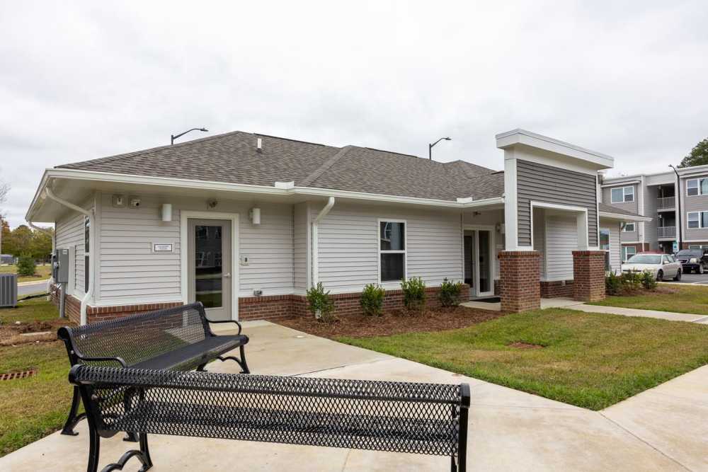 Gated entrance with benches and landscaped area near apartment community buildings at Pender Crossing in Wilson, North Carolina