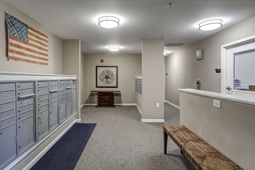 Apartment community lobby with mailboxes, bench seating, and American flag decor at Viewmont Square in Hickory, North Carolina