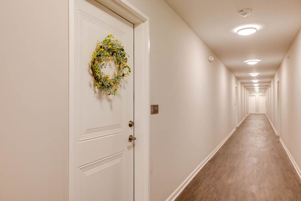 Hallway with decorated door and wood-style flooring at Williams Terrace in Indianola, Iowa