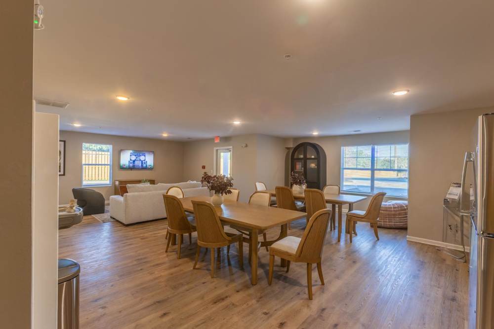 Spacious open layout with wood-style flooring, dining table, and comfortable seating area at Clemons Greene in Lexington, South Carolina
