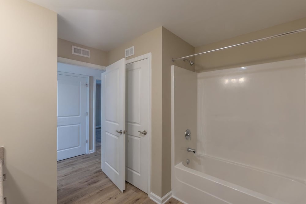 Bright bathroom with a tub, neutral walls, and wood-style flooring at Clemons Greene in Lexington, South Carolina