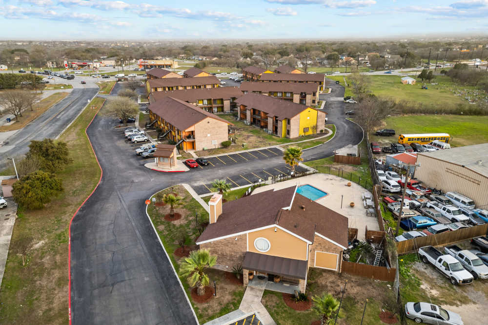 Aerial view of apartment community with parking, pool area, and landscaped grounds at Towne East Village Apartment Homes in Converse, Texas