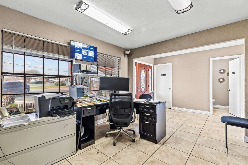 Office space with desk, computer, and printer, large windows providing natural light at Towne East Village Apartment Homes in Converse, Texas