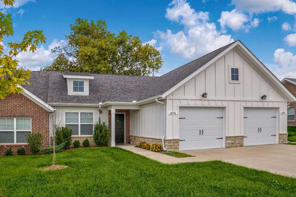 Charming apartment community with landscaped yard and two-car garage, inviting entrance and vibrant greenery at Brea's Crossing Senior Living II in Shelbyville, Kentucky