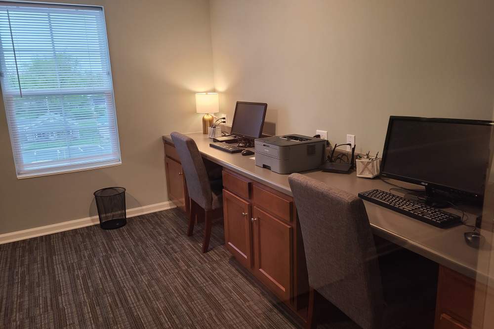 Home office with two desks, computers, printer, and natural light from window at Kirkman Terrace in Hopkinsville, Kentucky