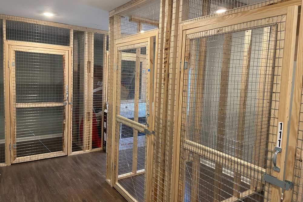 Indoor pet storage area with wooden enclosures and metal mesh doors at Kirkman Terrace in Hopkinsville, Kentucky