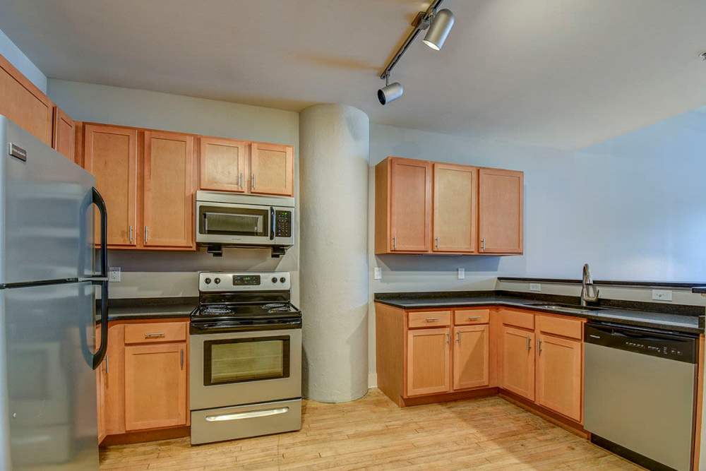 Fully equipped modern kitchen with wooden cabinets at Stone Center Lofts in Wheeling, West Virginia