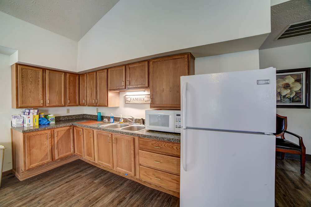 Modern kitchen with wood-style flooring, granite countertops, stainless steel appliances, and wooden cabinets at Madison Grove in Slippery Rock, Pennsylvania