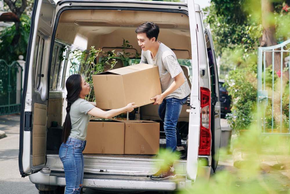 Kids unloading moving boxes from van at Katella-Beach RV Storage in Stanton, California