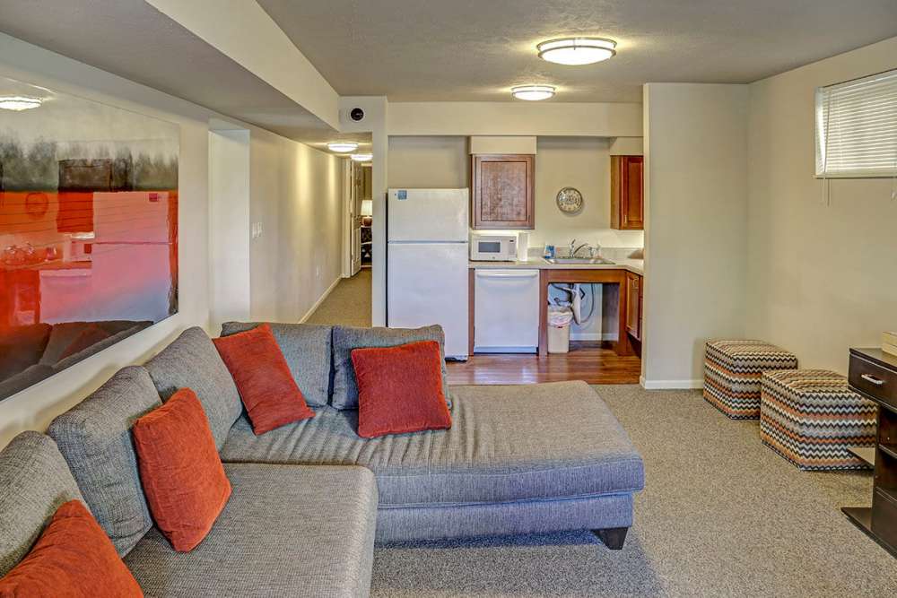 Cozy living area with gray sectional sofa and colorful accent pillows at Alston Park in Cincinnati, Ohio