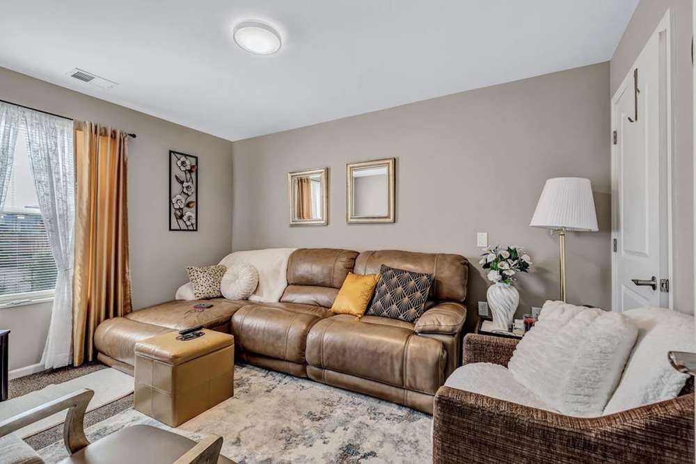 Living room with a couch and a large window at Audubon Crossing Senior Community in Dayton, Ohio 