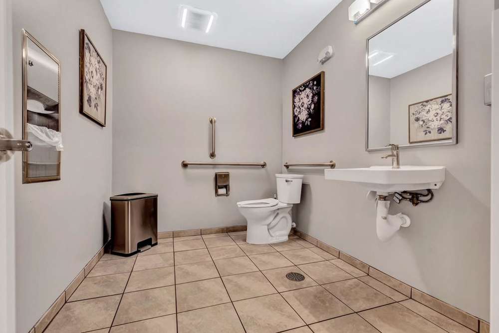 Bathroom with a toilet and a mirror at Audubon Crossing Senior Community in Dayton, Ohio 