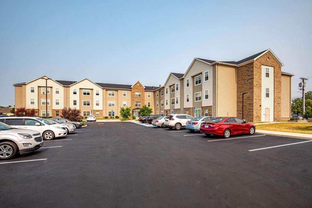 Multiple cars parked in front of the building at Audubon Crossing Senior Community in Dayton, Ohio 