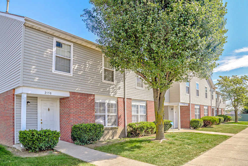 Lush green shrubs lining brick apartment exteriors at Glennview Apartments in Washington Court House, Ohio