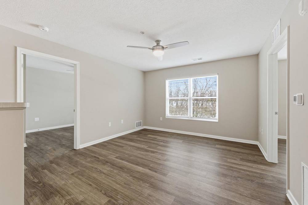 Spacious living area with wood-style flooring and large windows for natural light at Granville Woods Lofts in Columbus, Ohio