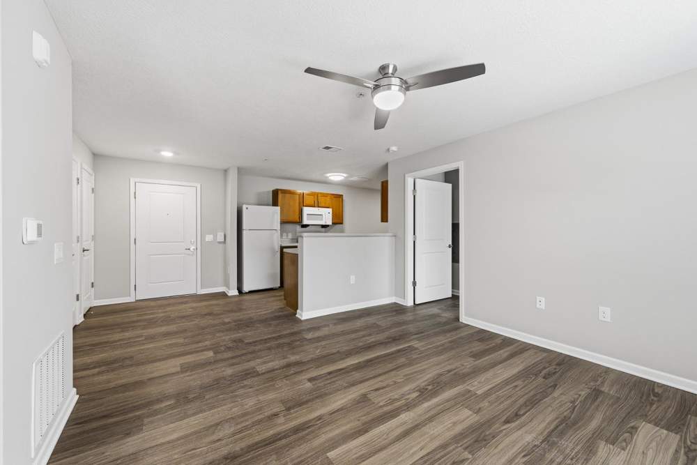 Open layout with wood-style flooring and modern kitchen featuring stainless steel appliances at Granville Woods Lofts in Columbus, Ohio