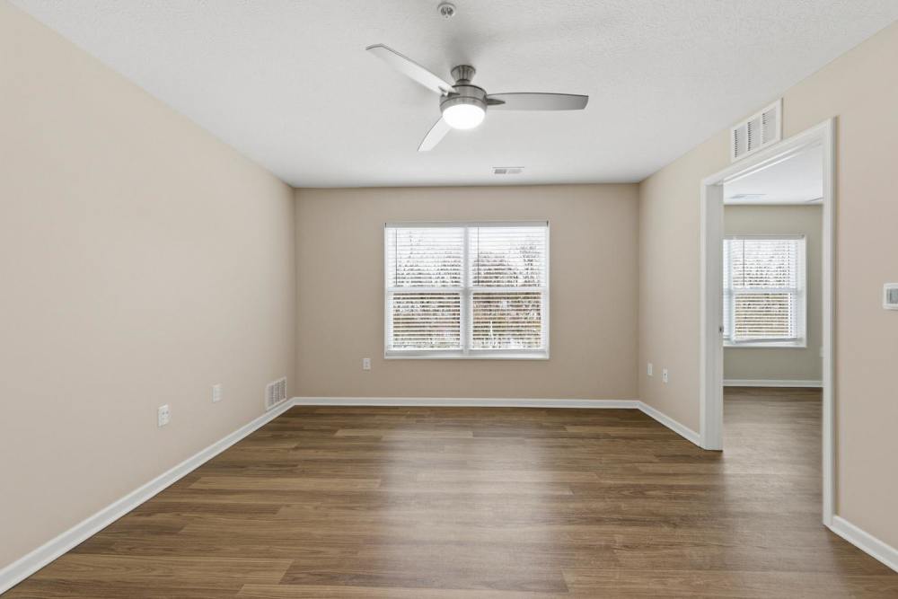 Spacious living area with wood-style flooring and ceiling fan at Granville Woods Lofts in Columbus, Ohio
