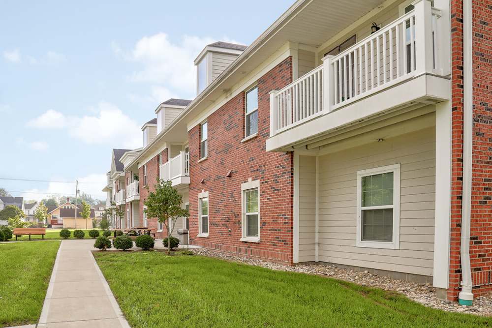 Gated entrance with landscaped grounds and balconies on apartment units at Hayden House in Springfield, Ohio