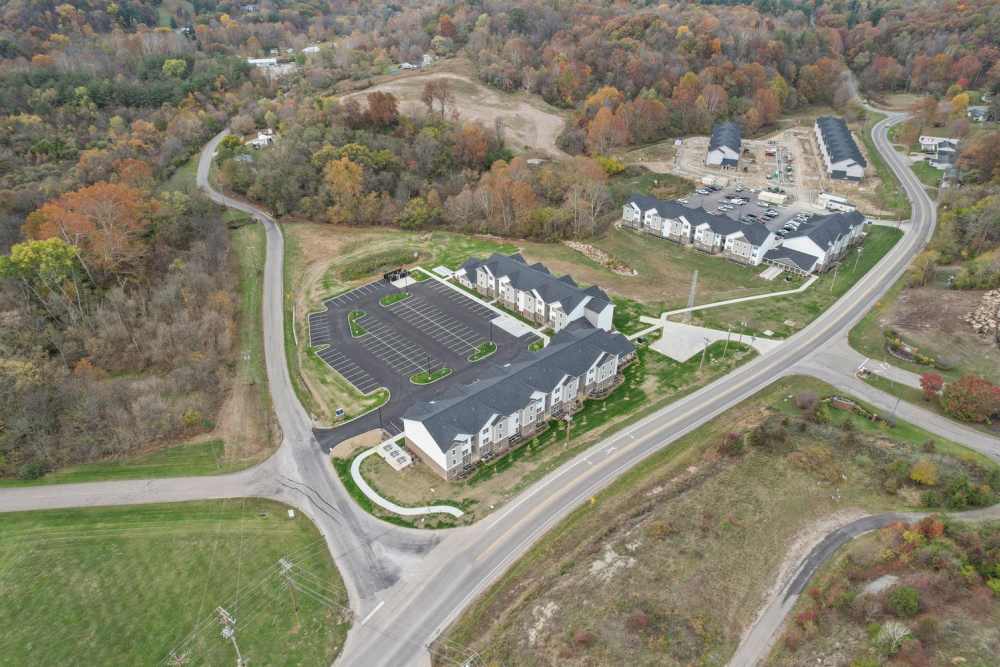 Aerial view of a modern apartment community with ample parking and surrounding greenery at Kershaw Greene II in Athens, Ohio