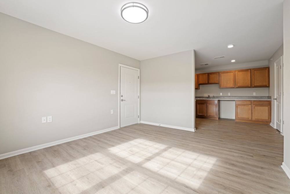 Open layout with wood-style flooring and kitchen featuring wooden cabinets at Kershaw Greene II in Athens, Ohio
