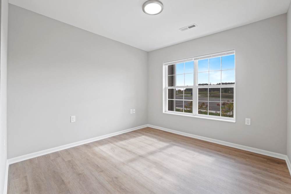 Bright room with wood-style flooring and large window offering natural light at Kershaw Greene II in Athens, Ohio