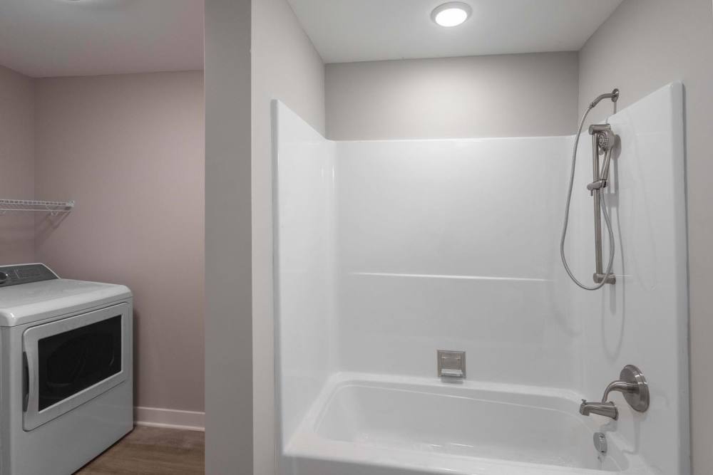 Laundry area with washer and dryer, modern shower with sleek fixtures at Sells Greene in Lancaster, Ohio