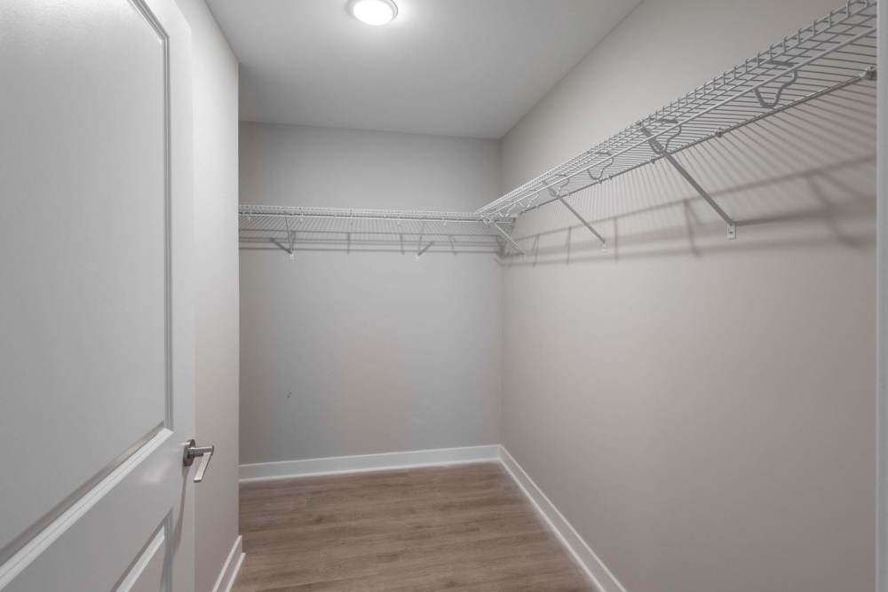 Spacious walk-in closet with wire shelving and wood-style flooring at Sells Greene in Lancaster, Ohio