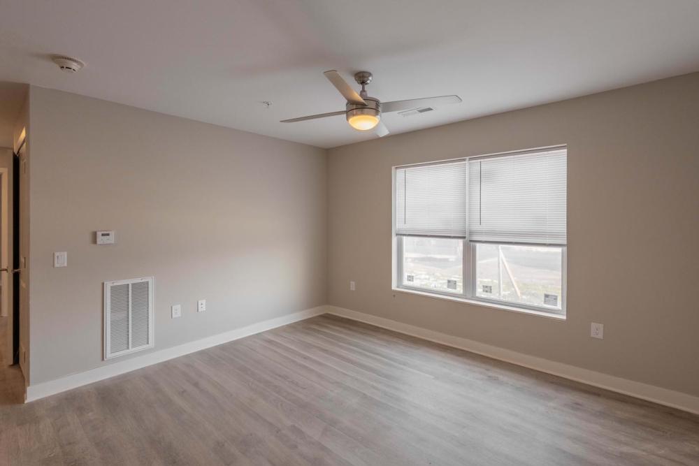 Spacious living area with wood-style flooring and large windows for natural light at Sells Greene in Lancaster, Ohio