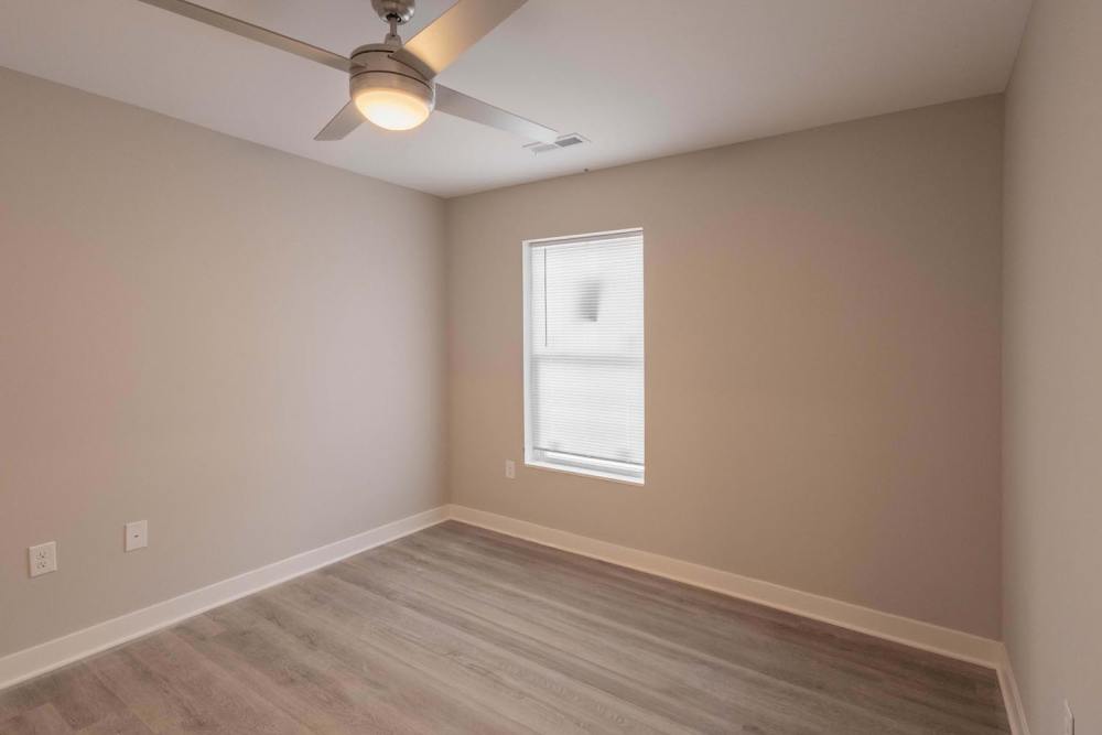 Bright bedroom with wood-style flooring and ceiling fan at Sells Greene in Lancaster, Ohio