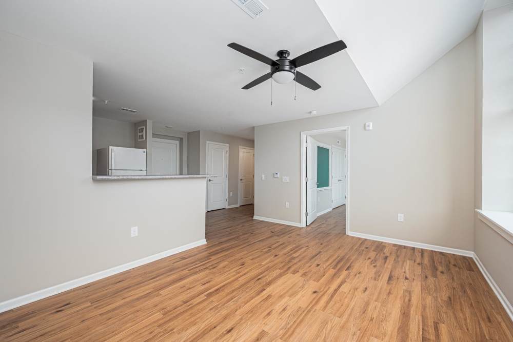 Open layout with wood-style flooring and ceiling fan in bright living area at Starling Yard in Columbus, Ohio