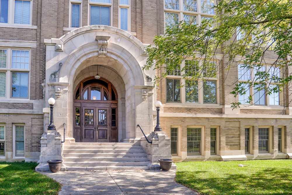 Building entrance with steps and large windows at Washington School Apartments in Washington Court House, Ohio