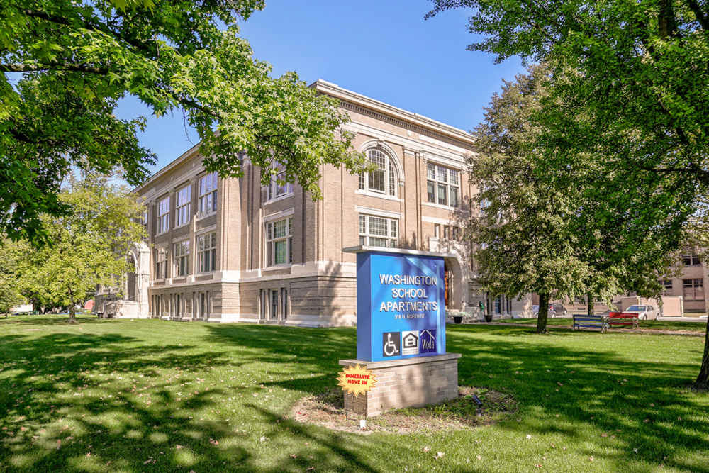 Historic building with green lawn at entrance near Washington School Apartments in Washington Court House, Ohio