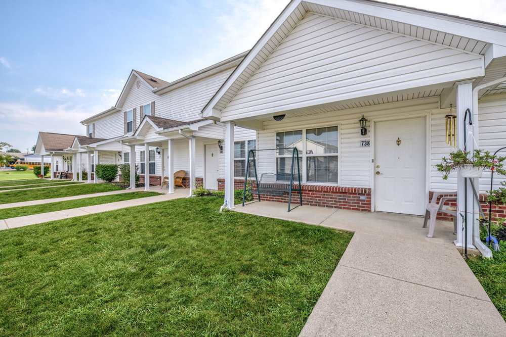 Row of apartment entrances with porches and green lawns at Webster Glen in Peebles, Ohio