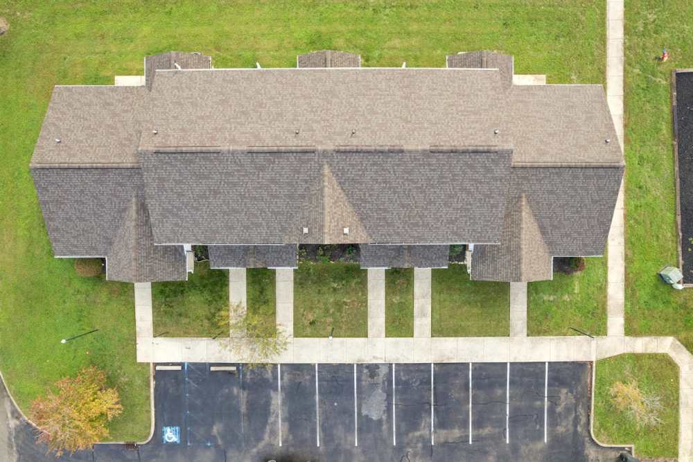 Aerial view of apartment community with landscaped lawns and parking spaces at Webster Glen in Peebles, Ohio