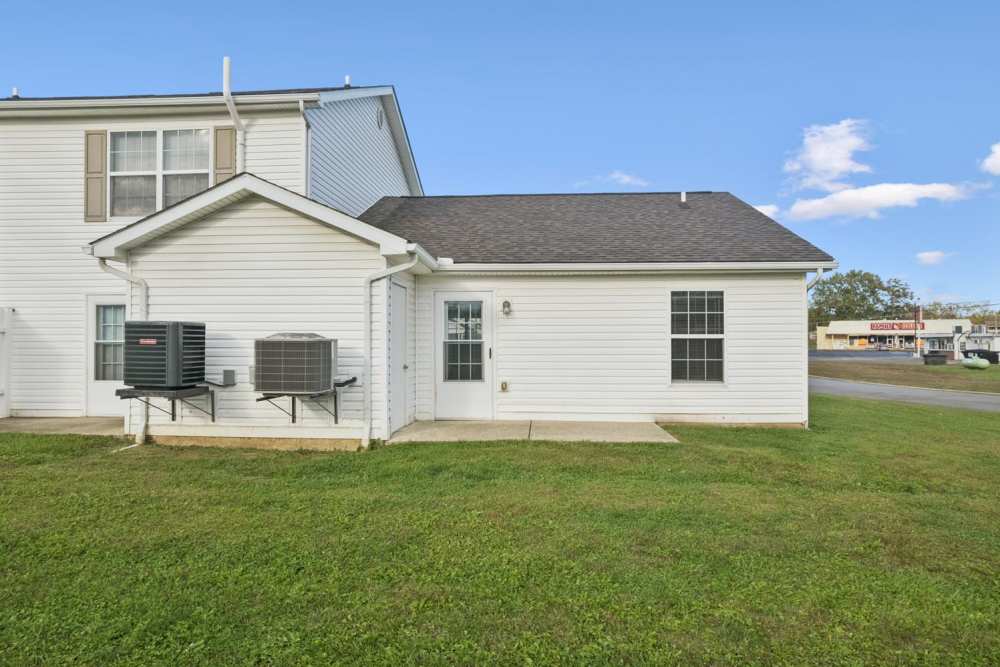 Single-story apartment exterior with grassy area at Webster Glen in Peebles, Ohio